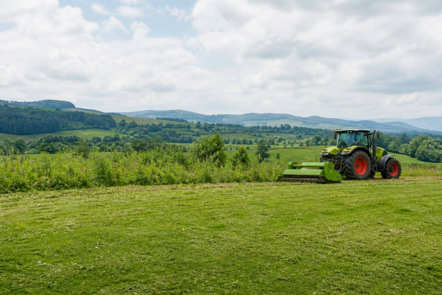 Údržba zeleně — traktor s frézou na udržovaném pozemku